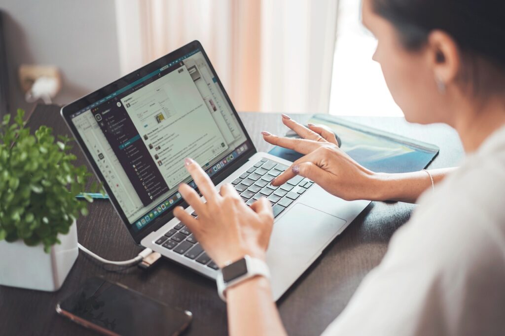 person researching jobs on laptop at home looking hopeful and focused