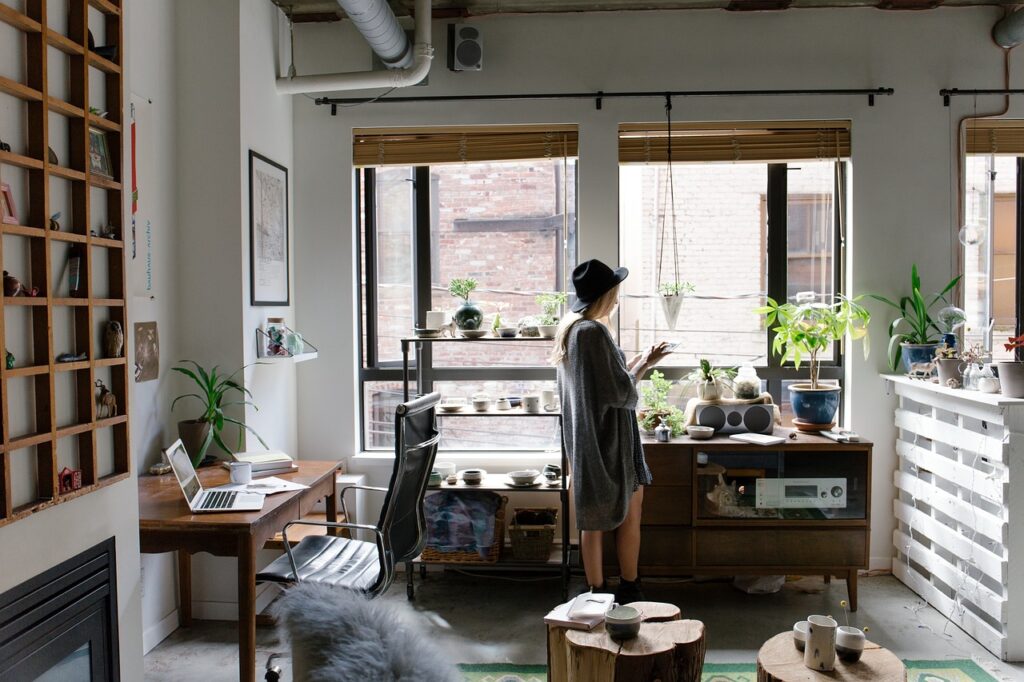 person working happily on laptop at home desk bright natural light